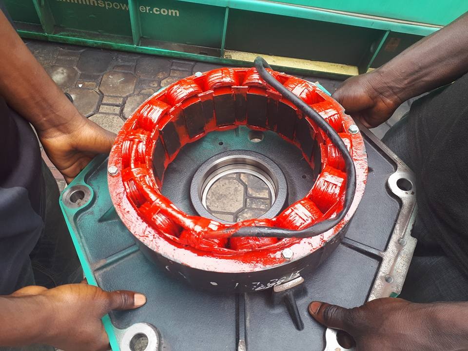 Hands working on a generator component